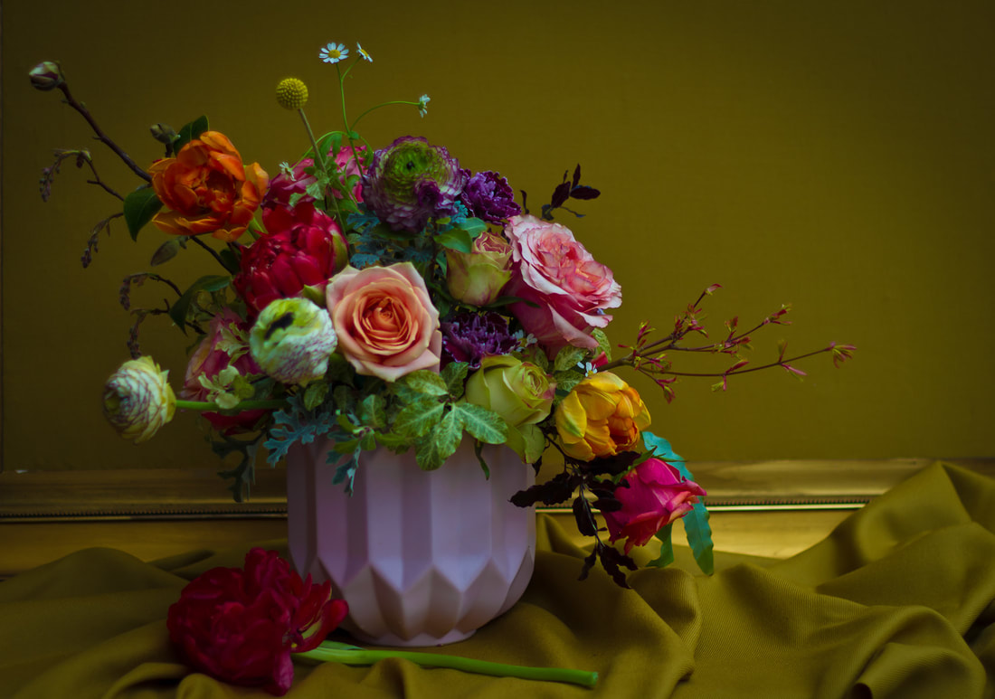 Colourful spring flower arrangement in geometric vase