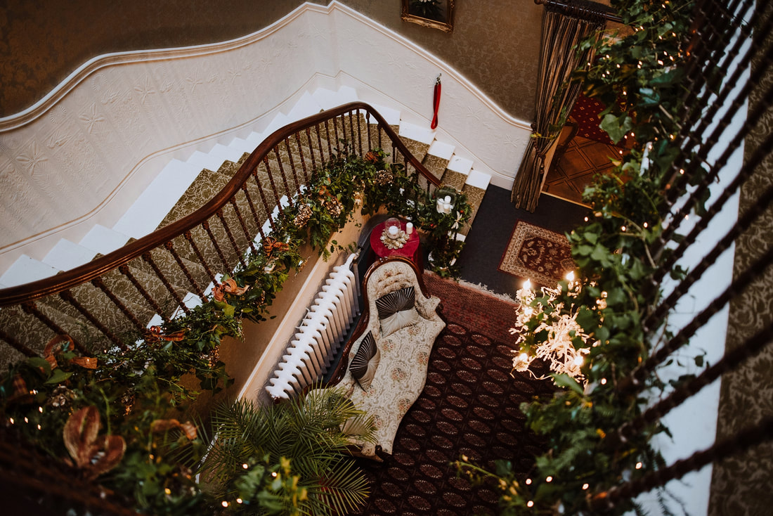 Staircase seen from above, draped in greenery and fairylights