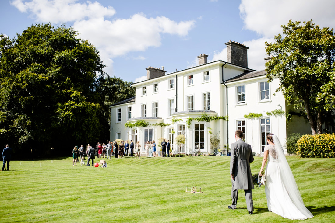 Bride and groom walk across the front lawns at Penton Park