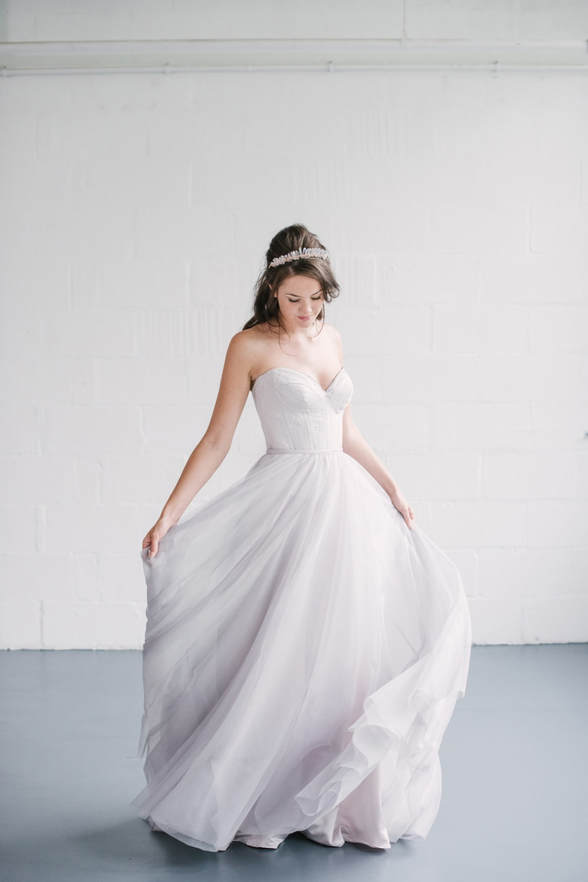 Model wears Naomi Neoh Venus gown, twirls silver-tinted skirt